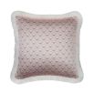 A pastel pink cushion with white floral details and a fringed edge