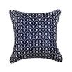 An art deco inspired square cushion with white floral motifs on a dark blue background