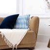A simple blue and white, diamond striped cushion with matching white piped edges.