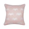 A cute pastel pink cushion with white piping and leaf-like design