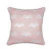 A cute pastel pink cushion with white piping and leaf-like design