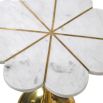 A glamourous floral inspired side table with a white marble flower shaped top and a brushed brass base