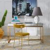 A glamorous, modern desk with a antiqued mirror table top and a polished brass base