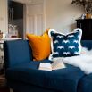 A gorgeous dark blue cushion with a white pattern and elegant fringe