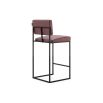 A luxurious modern counter stool with a minimal black metal frame and natural leather upholstery