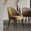 Elegant, modern luxury dining chair with back seat pleating, black legs and gold accents