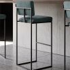 A chic, modern bar stool with a minimal black metal frame and velvet upholstery 