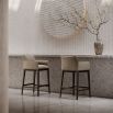 A sophisticated bar stool by Domkapa with a luxury upholstery and solid wood structure