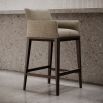 A sophisticated bar stool by Domkapa with a luxury upholstery and solid wood structure