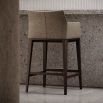 A sophisticated bar stool by Domkapa with a luxury upholstery and solid wood structure