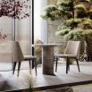 A luxury dining chair by Domkapa with a sophisticated upholstery and opulent wooden legs
