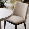 A luxury dining chair by Domkapa with a sophisticated upholstery and opulent wooden legs