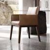 A luxury leather dining armchair by Domkapa with a sophisticated wooden base and double-top stitching