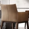 A luxury leather dining armchair by Domkapa with a sophisticated wooden base and double-top stitching