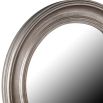 A contemporary round distressed mirror in a silver finish