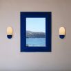 Sculpted wall sconce with a deep blue fixture and a frosted glass shade