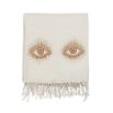 A luxurious, natural-toned hand-embroidered throw with golden accents