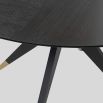 Dining table with statement base of slender spokes and oak veneer top