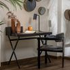 Black sculptural desk with metal legs and wooden table top