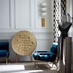 A stylish hand-hammered brass bar cabinet with polished brass legs and interior shelving