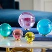 A set of luxurious coloured acrylic orbs with polished brass stands 