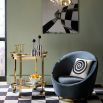 The Op Art Bar Cart showcases bold modernism with back-painted glass shelves and polished brass accents, offering ample space for decanters and easy mobility.
