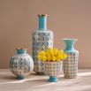 A porcelain pedestal bowl with a light blue glaze and gold caning, combining preppy sophistication with modern elegance.