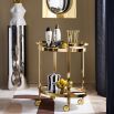 The Chambeige Bar Cart features back-painted glass shelves in a captivating Chambeige hue, framed by polished brass for a glamorous touch.
