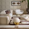 The Beaumont Lounge Chair combines minimalist design with luxurious comfort, featuring a sculptural brass base and elegant upholstery in velvet or bouclé.