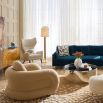 The Pompidou Lounge Chair is a deep, cozy cocoon with a tubular framework, upholstered in Valais Latte bouclé for ultimate comfort.