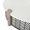 Round coffee table with a concrete top, four wooden dowels, and a black and white geometric print exterior