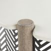 Round coffee table with a concrete top, four wooden dowels, and a black and white geometric print exterior
