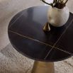 Side table with sharp antique brass base and black round table top