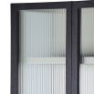 A decadent display cabinet with fluted glass doors and brass handles