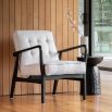 Armchair with a dramatic black solid oak angled frame and contrasting natural weave upholstery