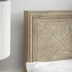 Light wooden superking size bed with cross pattern on headboard