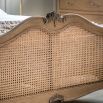 French-style wooden bed with rattan headboard
