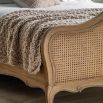 French-style wooden bed with rattan headboard