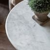 Glass-based side table with sculptural silhouette and round marble top