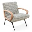 The Gainsbourg Lounge Chair is a vintage-inspired piece with a cushy seat, cerused ash wood arms, and blackened metal legs, perfect for pairing with a sofa.
