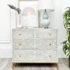 A gorgeous bone inlay chest of drawers with a stainless steel base 