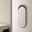 The Inset Long Mirror features a glossy surface within a textured bronze-plated aluminium frame, offering versatile display options and unique variations in finish.