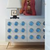 A chic, white lacquer sideboard with acrylic cabochons and brass legs 