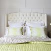 Designer French style bed with a curved, button back headboard and studding