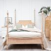 A luxurious acacia and cane 4 poster bed with a rattan headboard