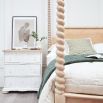 A beautiful superking bed with twisted columns and a rattan headboard.