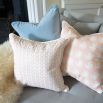 A beautiful blush pink coloured cushion with a geometric design