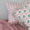 A gorgeous pink children's cushion with a unique pattern and white piping
