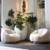 A cosy, boucle cream segmented swivel armchair with a brushed brass base