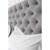 Grand luxury upholstered bed, with deep buttoned headboard, sharp wings and piping detail